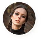 Young woman with braided hair and smoky eye makeup.