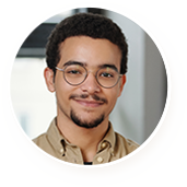 Smiling young man with glasses and short curly hair.