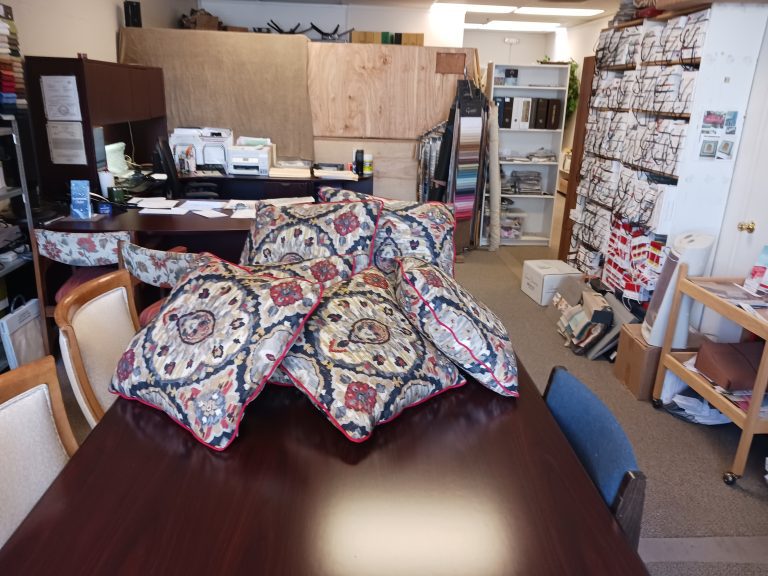 Decorative pillows with intricate designs on a conference table.