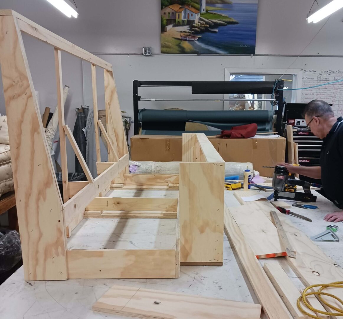 Wooden model ship frame under construction on a workbench.