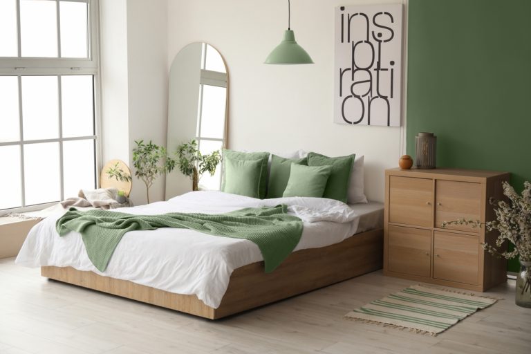 Cozy bedroom with green and white decor, wooden bed, and inspirational wall art.