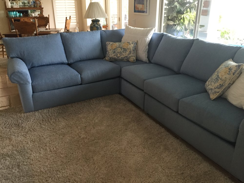 Blue sectional sofa with patterned pillows in a cozy living room.