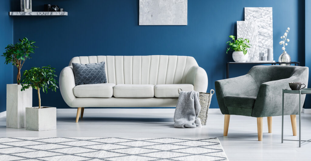 Modern living room with a white sofa against a blue wall.