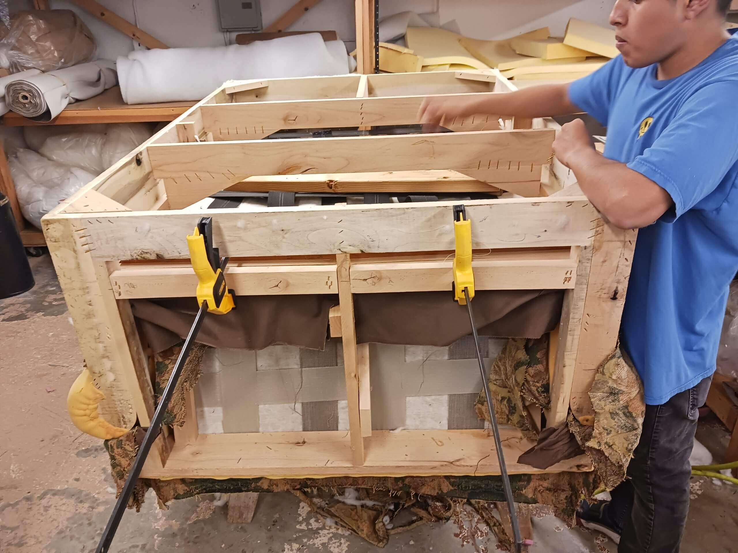 Upholsterer using clamps on sofa frame