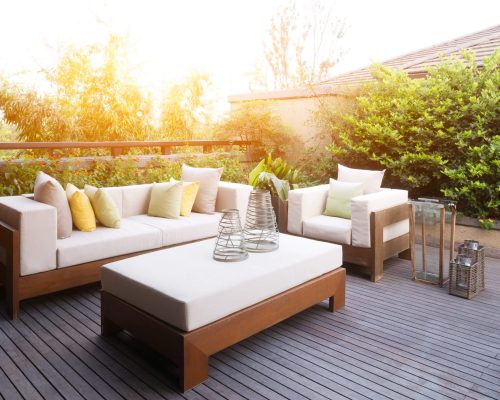Modern outdoor patio with elegant seating and warm sunlight.